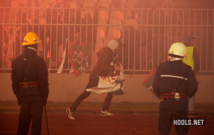 A Partizan hooligan runs with a captured Augsburg flag.