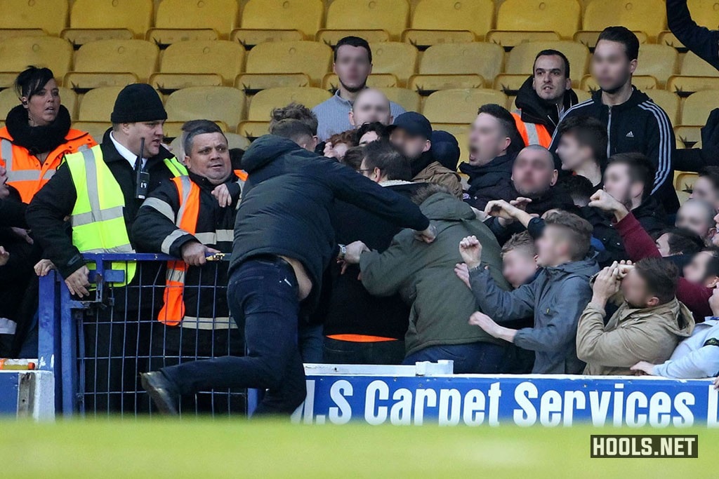 A Southend United fan attacks rival Colchester United supporters during the Essex derby at Roots Hall.