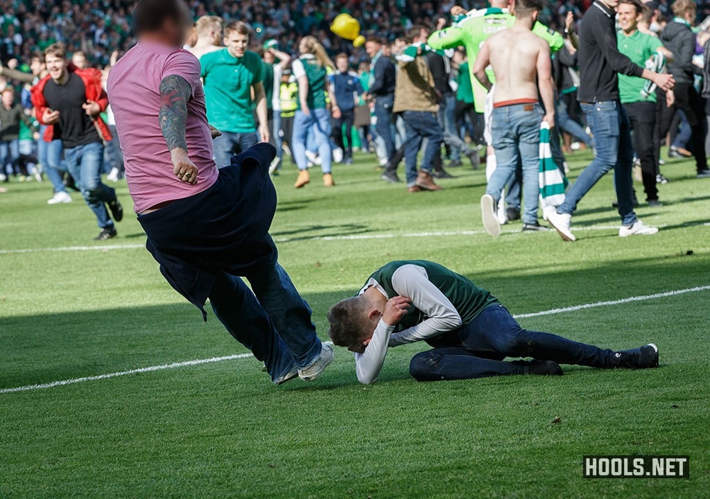 A Rangers fan kicks a Hibernian fan in the head.