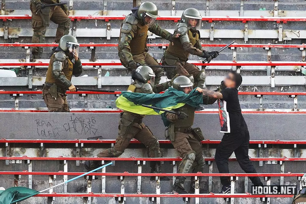 A Santiago Wanderers fan clashes with cops in the stands during the Chilean Super Cup final.