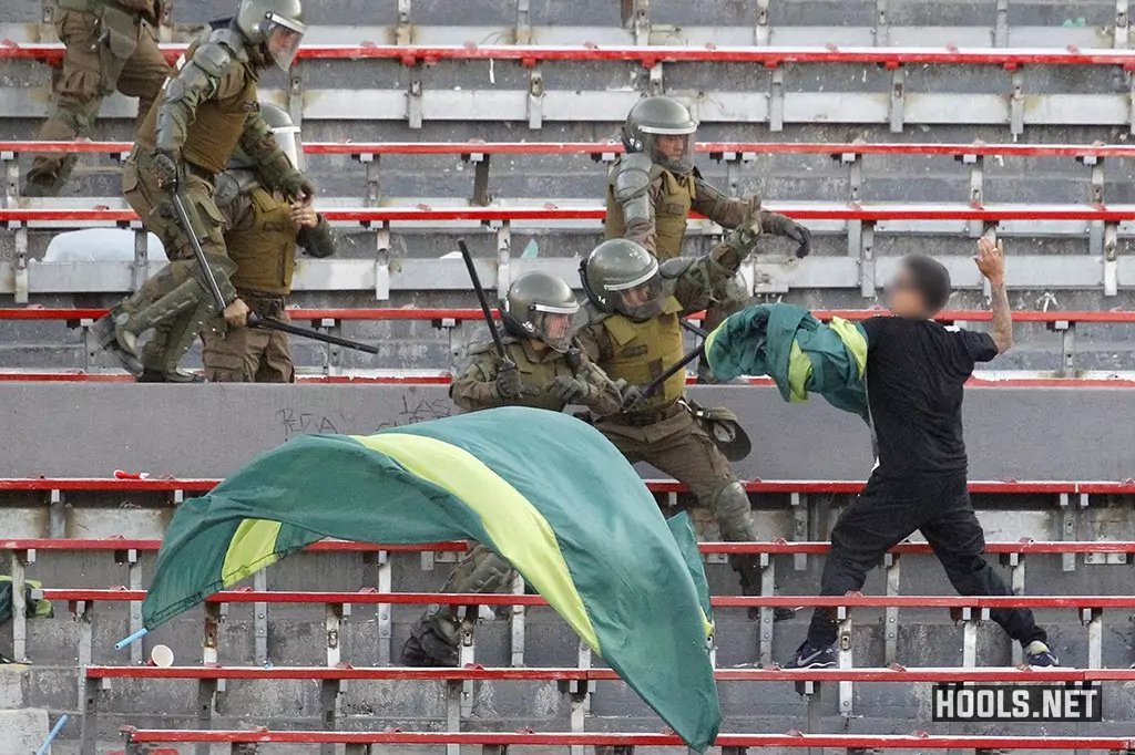 A Santiago Wanderers fan clashes with cops in the stands during the Chilean Super Cup final.