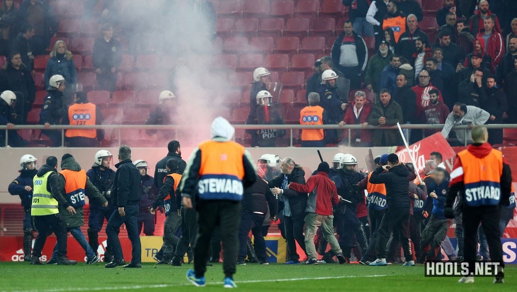 Olympiacos hooligans clash with riot police on the pitch