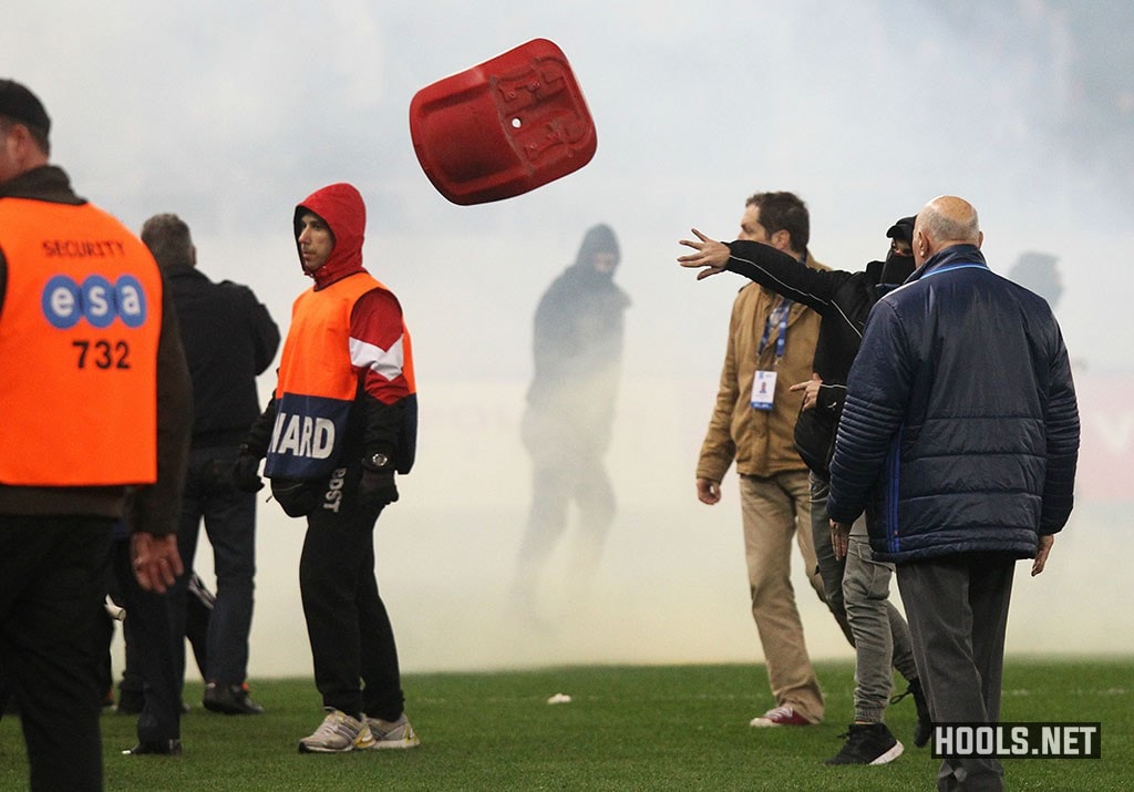 An Olympiacos hooligan throws a seat at riot cops