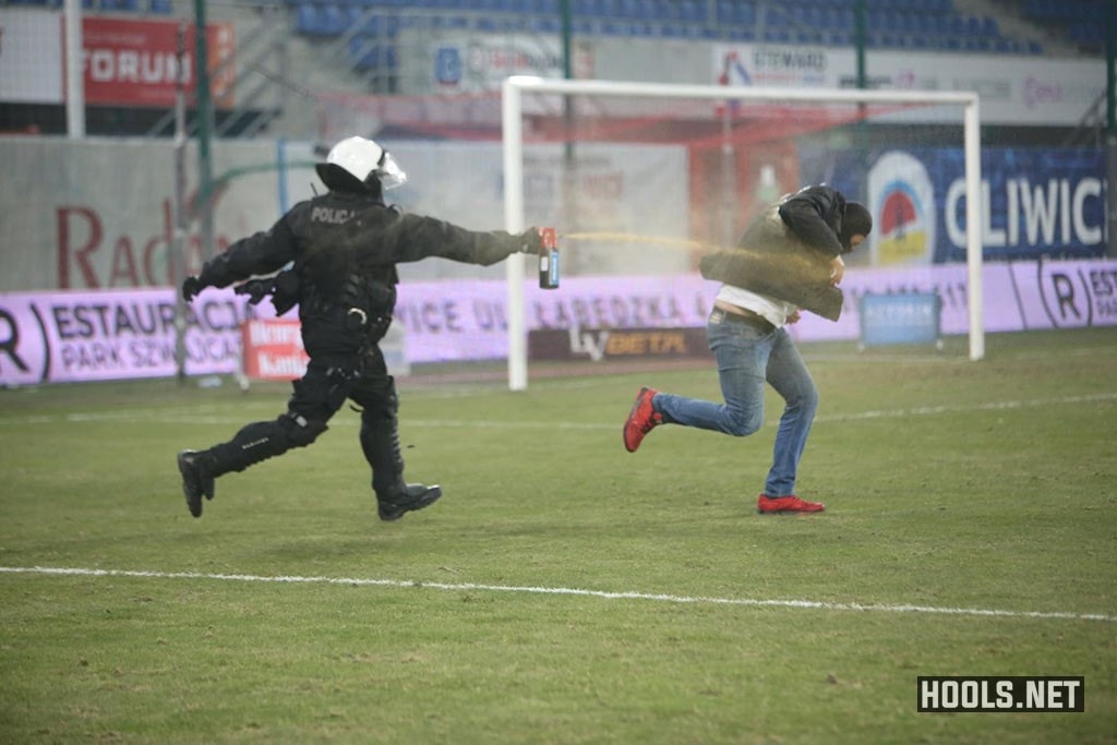 A cop uses pepper spray against a Piast Gliwice fan