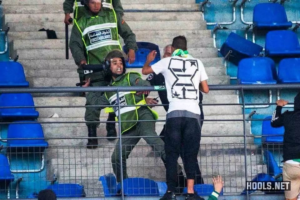 A cop uses a baton to hit a Raja Casablanca supporter