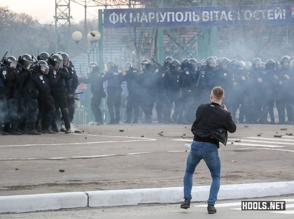 A Dynamo Kyiv hooligan throws a stone towards cops