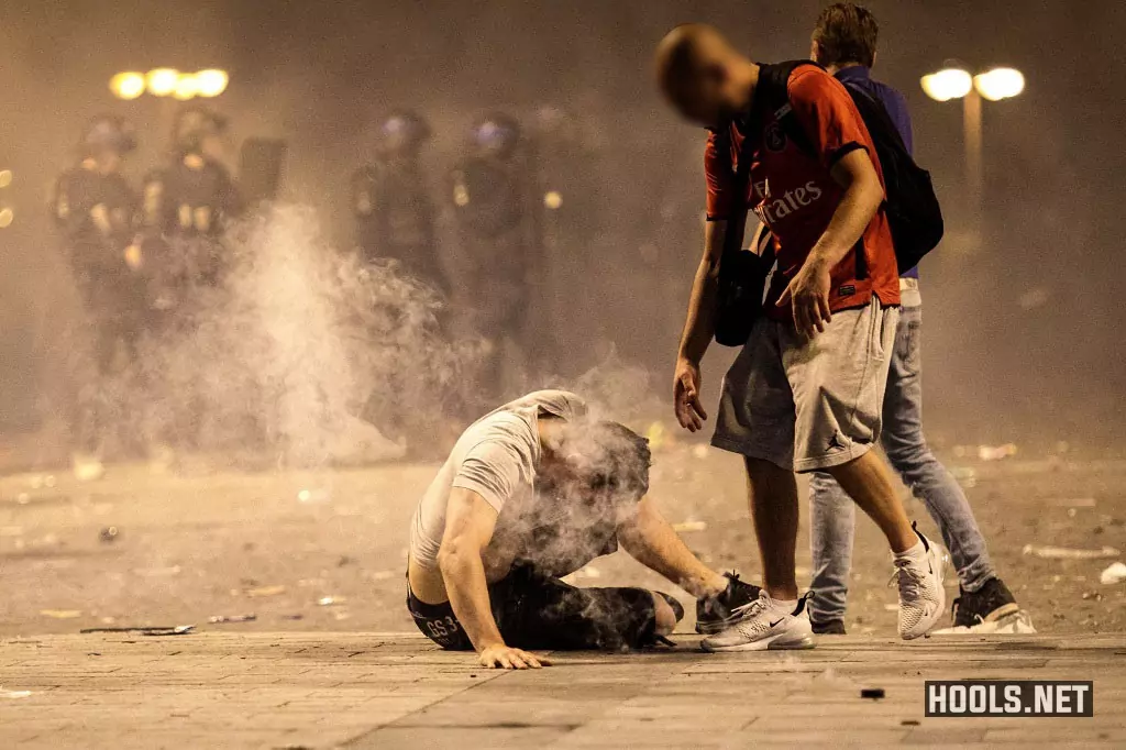 A man falls to the floor after inhaling tear gas as French fans clash with riot cops.