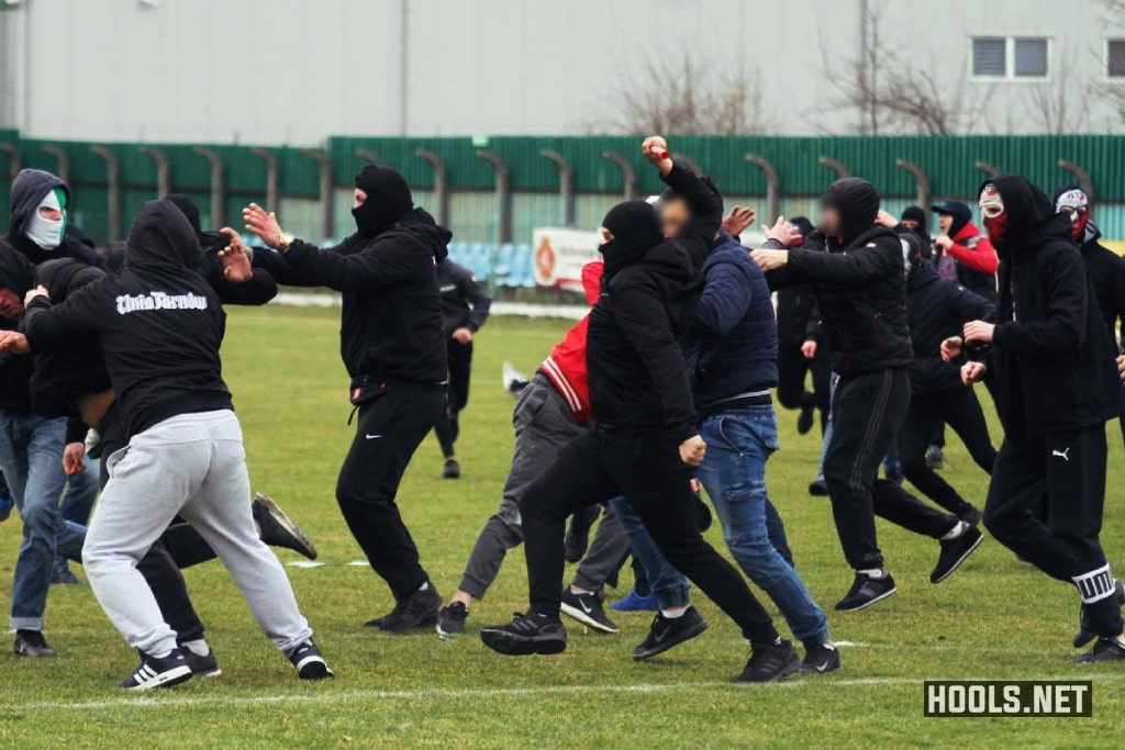 Okocimski Brzesko and Tarnovia Tarnow fans fight as they invade the pitch during the match.
