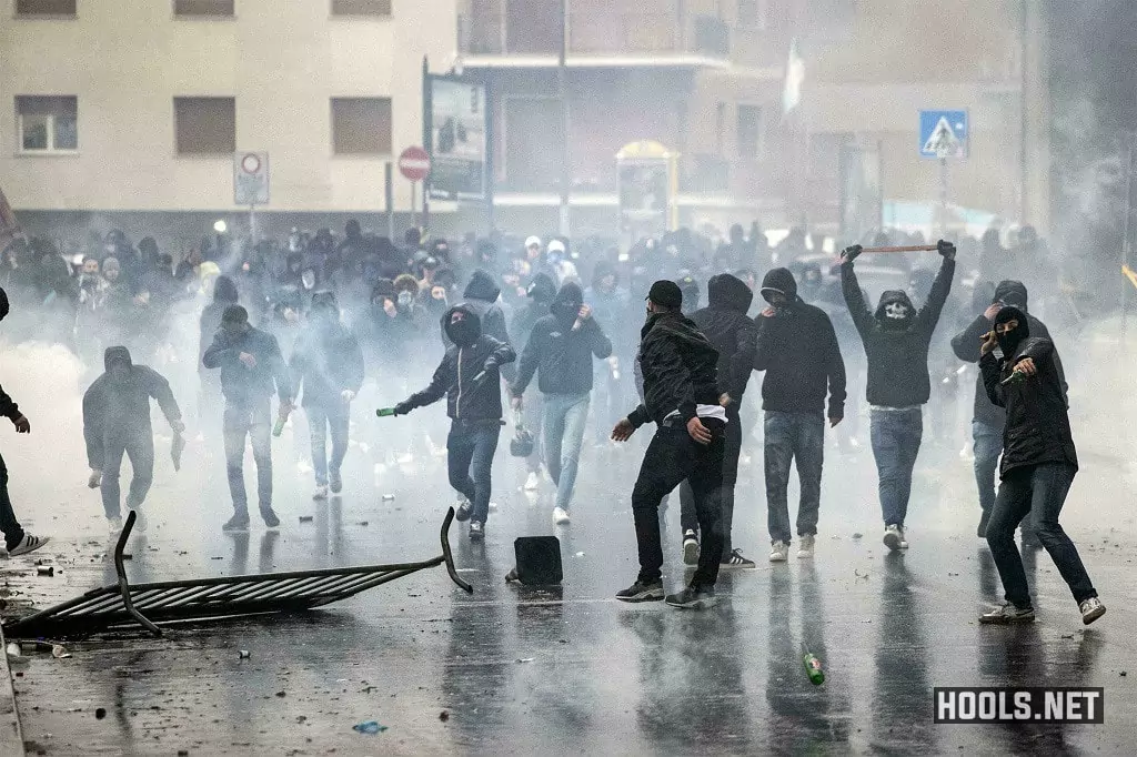 Lazio hooligans throw rocks and bottles at riot police.