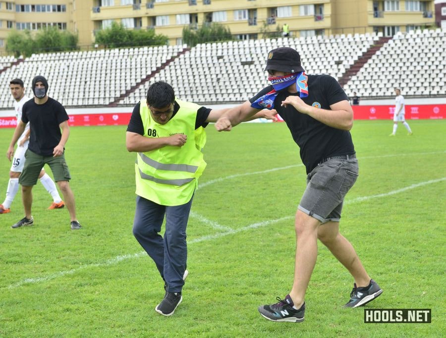 A Steaua Bucuresti fan punches a steward in the face.