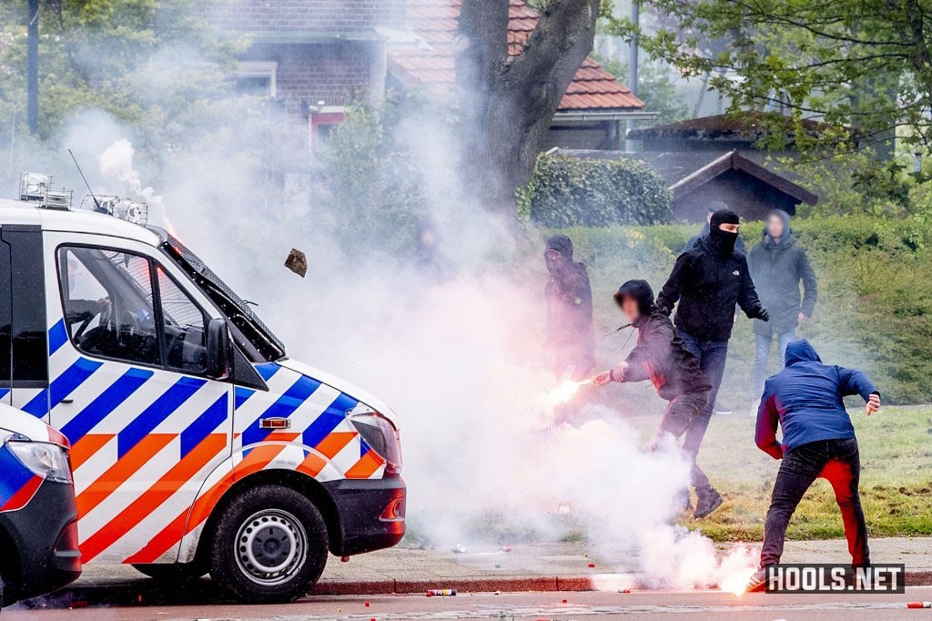 Feyenoord fans throw flares and stones at police vans.