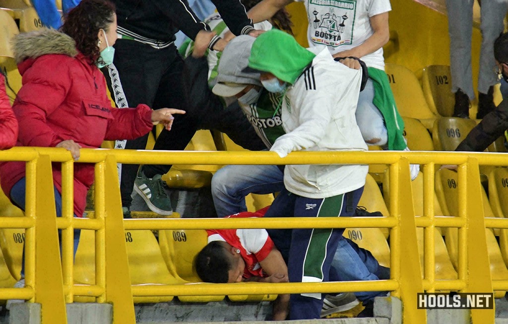 Atletico Nacional fans violently kick a Santa Fe fan.