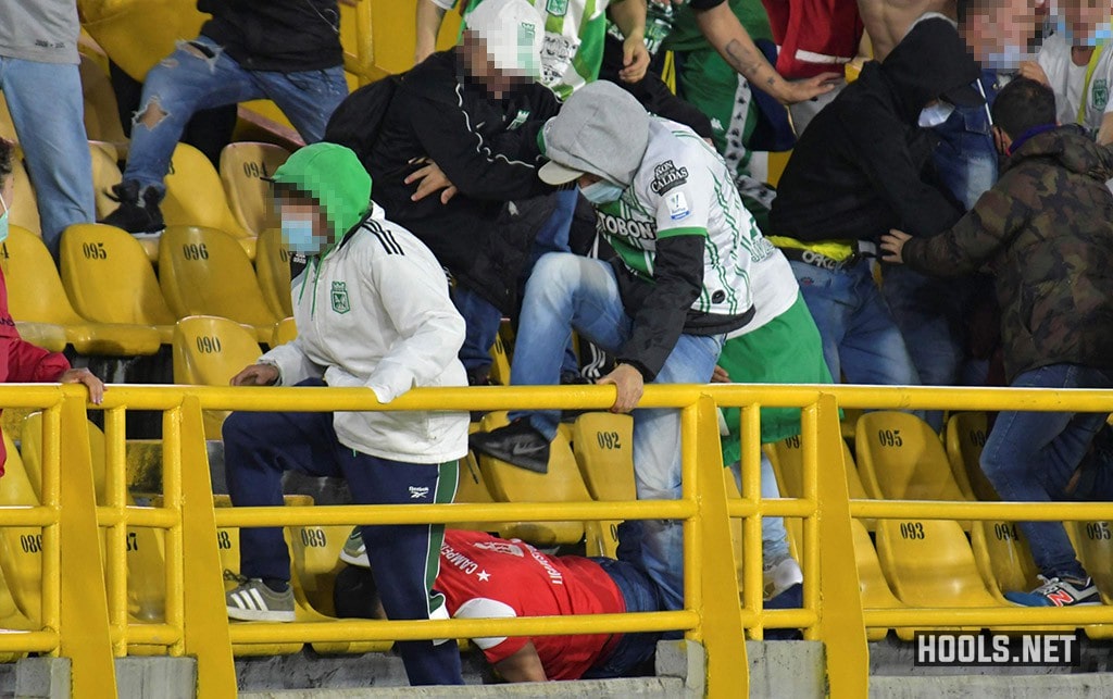 Atletico Nacional fans violently kick a Santa Fe fan.