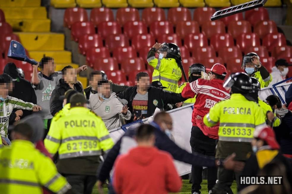 Santa Fe and Atletico Nacional fans clash on the pitch at half time of their Categoria Primera A match at Bogota's El Campin stadium.