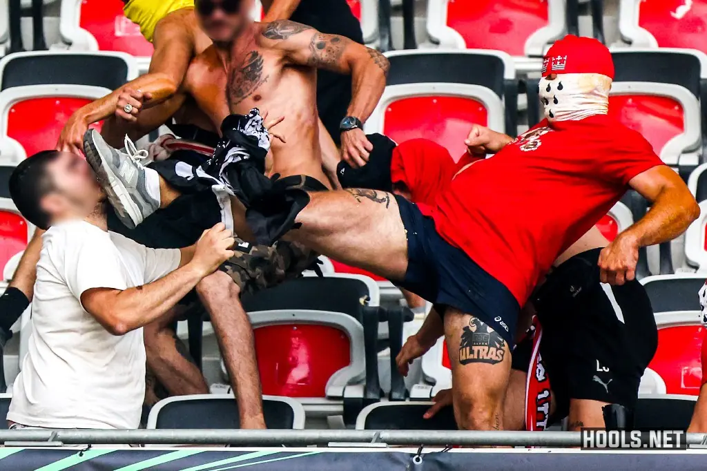 A Cologne fan kicks a Nice supporter in the face