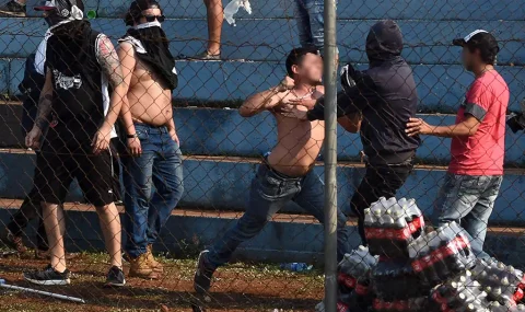 Olimpia fans fight each other during Sol de America game